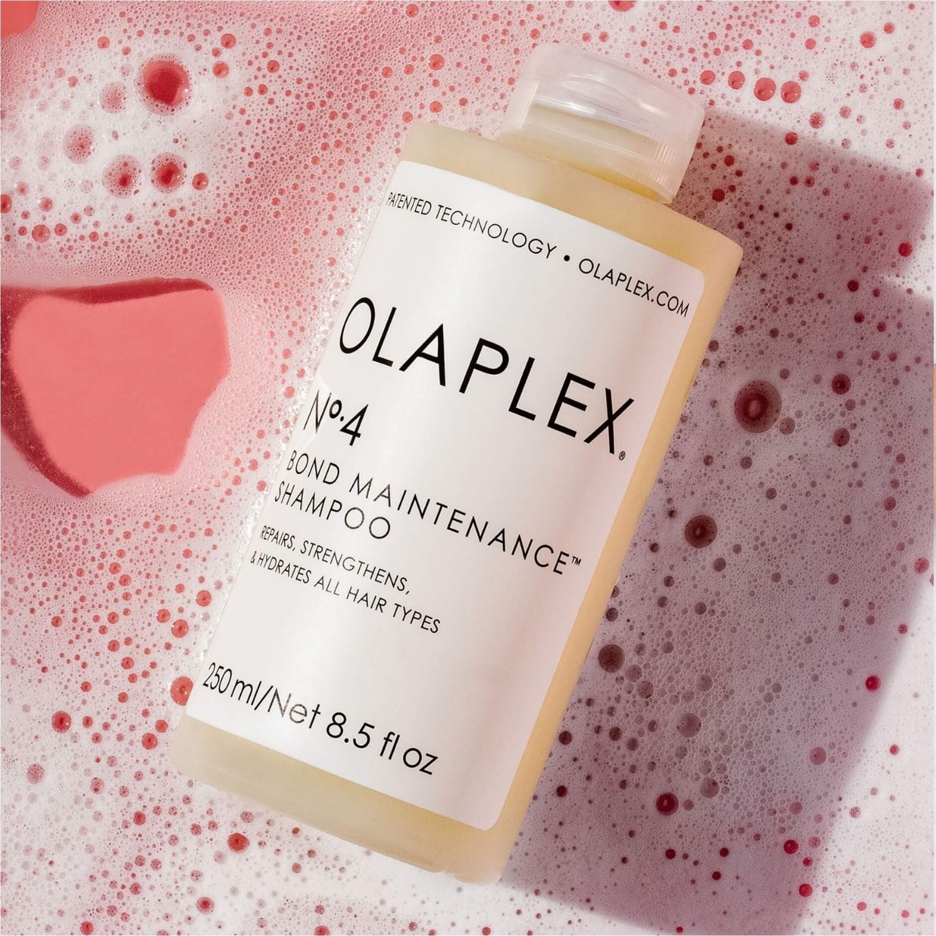 Olaplex No. 4 Bond Maintenance Shampoo bottle in pink foam