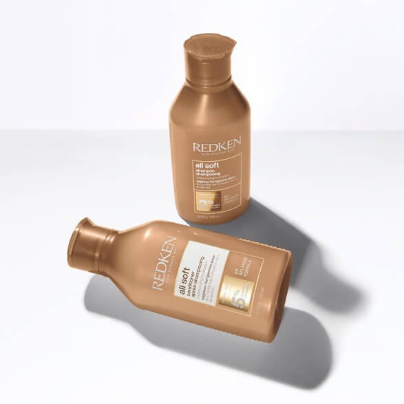Range of Redken professional hair care products, including shampoos, conditioners, and styling treatments